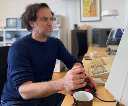 Der Projektverantwortliche Eugen Pfister sitzt am Computer und spielt emotional engagiert ein Computerspiel.