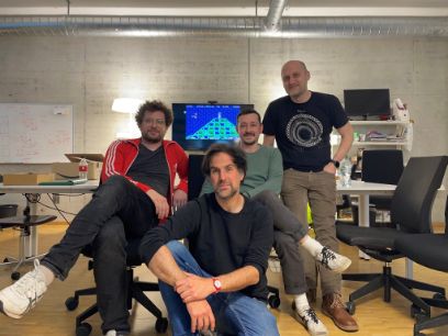 Vier Männer aus dem Forschungsteam posieren vor einem Screen, auf welchem ein Comperspiel geöffnet ist.