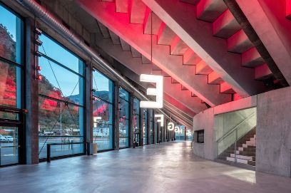 Innenansicht Mehrzweckarena Visp, grosse leuchtende Buchstaben an der Decke montiert, Beton