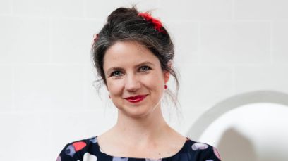 Eine Frau steht vor einem grauen Hintergrund (Meret Lüthi).