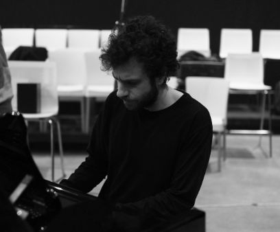 Ein schwarz-weiss Bild von einem Mann, der am Klavier sitzt.
