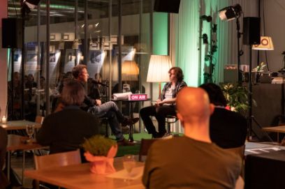 Aufnahme aus dem Buffet Nord an der Fellerstrasse 11 in Bern. Zwei Personen sitzen an einem Tisch und nehmen eine Podcast-Folge auf.