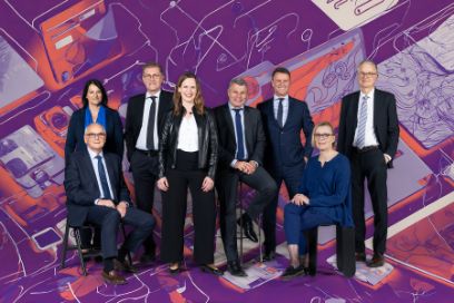 Der Berner Regierungsrat stellt sein neues Regierungsfoto vor. Christine Häsler, Pierre Alain Schnegg, Christoph Neuhaus, Evi Allemann, Christoph Ammann, Philippe Müller, Astrid Bärtschi und Christoph Auer stehen/sitzen vor einem illustrierten Hintergrund in violett-roten Tönen.