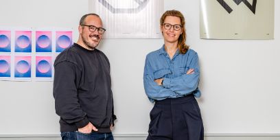 Ein Mann und eine Frau schauen in die Kamera und lächeln.