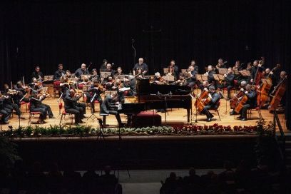 Raman Kamisarau am Flügel während des Auftrittes, im Hintergrund das Orchester.