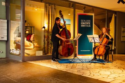 Zwei Musizirende an Cello und Bratsche, vor einem Schaufenster. Bild aufgenommen an den Schlosskonzerten Thun 2022