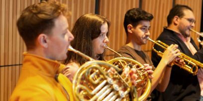 Vier Personen spielen auf Blasinstrumenten.