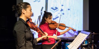 zwei Personen an Geigen seitlich fotografiert