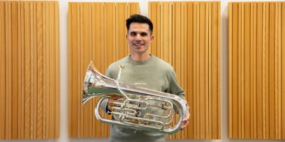 Der junge Mann trägt sein Euphonium vor sich