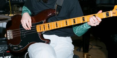 Bildausschnitt einer Person an einer E-Gitarre/Bass