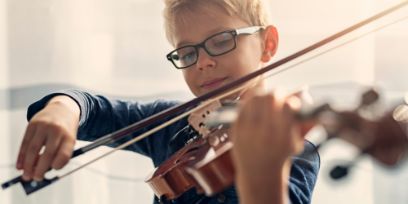 Ein Junge spielt Violine, aufgenommen in Frontalansicht