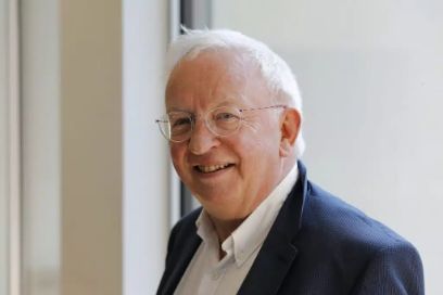 Ein älterer Mann mit weissen Haaren und Brille schaut mit leicht gedrehtem Kopf in die Kamera.