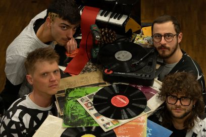 Vier Musiker um geben von Platten, Plattenspieler und mini Klavier