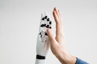 Titelbild Abendveranstaltung Kaderforum. Es sind zwei Hände zu sehen; eine menschliche Hand und eine Roboterhand.