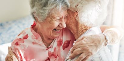 Zwei ältere Frauen umarmen sich zärtlich.