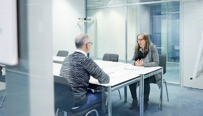 Zwei Personen diskutieren an einem Tisch